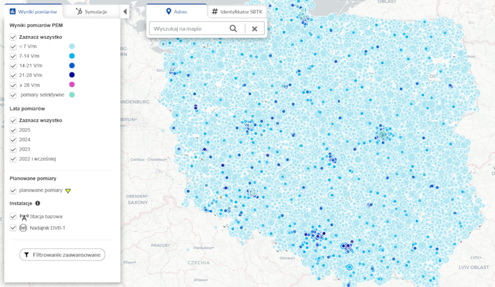 Mapa Polski przedstawiająca wyniki pomiarów PEM (pola elektromagnetycznego) w różnych lokalizacjach. Punkty pomiarowe są oznaczone okręgami o różnych odcieniach niebieskiego, granatowego i różowego, które odpowiadają różnym poziomom natężenia pola (w V/m). Po lewej stronie widoczna jest legenda z kategoriami natężenia PEM, latami pomiarów oraz typami instalacji (stacje bazowe i nadajniki DVB-T). Mapa zawiera także opcję wyszukiwania lokalizacji oraz filtrowania wyników. Największe zagęszczenie ciemnych punktów, oznaczających wyższe wartości PEM, występuje głównie w południowej Polsce.